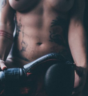 A photo of a woman's abs and a boxing glove